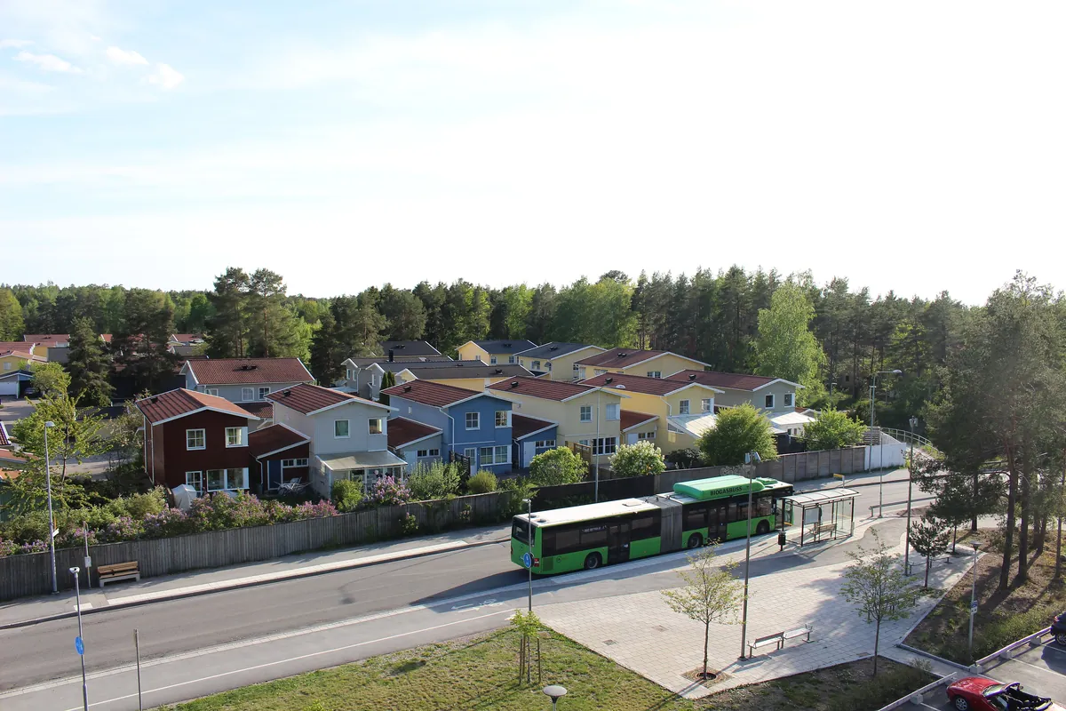 Färgglada radhus i Sävja, Uppsala, vid en gata med busshållplats