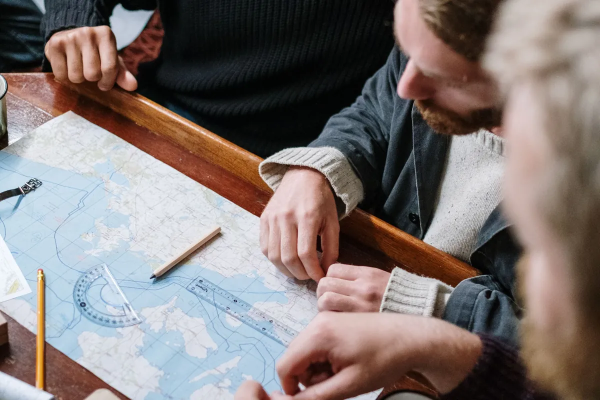 Personer samlade kring en karta på ett bord under ett möte